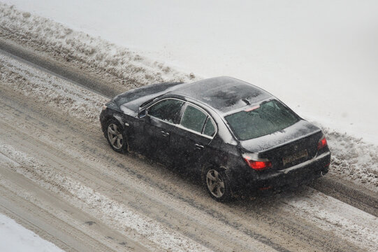Belarus, Minsk-16.12.2022:BMW 5 Series  is driving on a snowy road in a city in a snowfall.BMW 5 Series Generation V E60/E61.