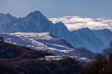 Fototapeta na wymiar Beautiful Mountain Landscape. Panoramic view of the snow-covered winter mountains of the Greater North Caucasus. Elbrus, Upper Balkaria, Kabardino-Balkaria, Russia.