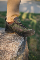 A military man in a special uniform and protective tactical sneakers. Special waterproof sneakers for soldiers in khaki and green