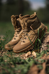 Khaki tactical military sneakers on dry grass