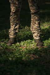 A military man in a special uniform and protective tactical sneakers. Special waterproof sneakers for soldiers in khaki and green