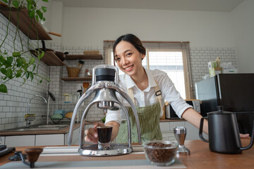 Asian women use a manual process to make espresso with a classic espresso machine at home.