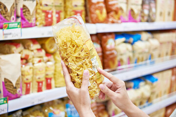 Woman with package pasta in shop