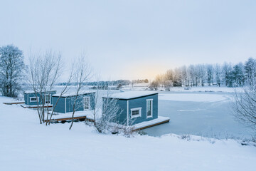 Fototapeta na wymiar Wooden cabins in the winter scenery with a sunrise