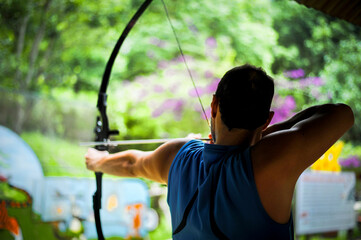 man stretches a bow for practicing archery