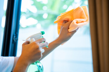 Part of woman clean window glass at home. Image of young girl housekeeper cleaner, housekeeping housework or chores.