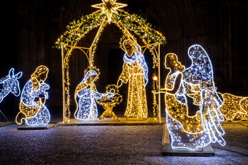 Christmas Manger scene art made many led bright garland lit lamps against old ancient Magdeburg Dom...