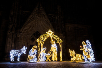 Christmas Manger scene art made many led bright garland lit lamps against old ancient Magdeburg Dom Church background. Light world lichterwelt city new year xmas decoration in Germany Saxony-Anhalt
