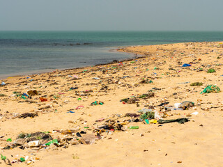 Beach sand and ocean with so many garbage plastic pollution in Senegal