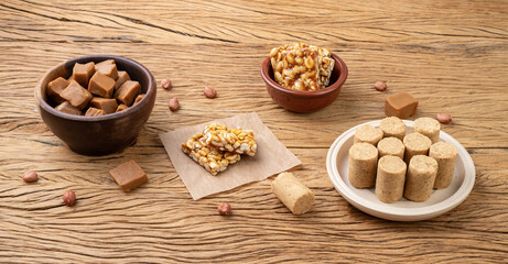 Typical brazilian candies over wooden table. Doce de leite or dulce de leche, pe de moleque and pacoca