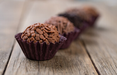 Typical brazilian chocolate brigadeiros over wooden table, short depth of field