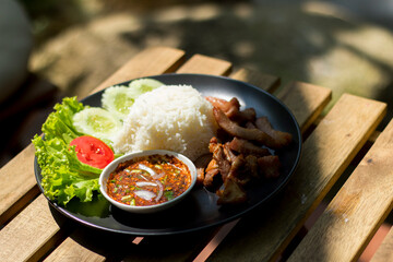Fried pork rice with healthy vegetables placed on wooden table, natural background.