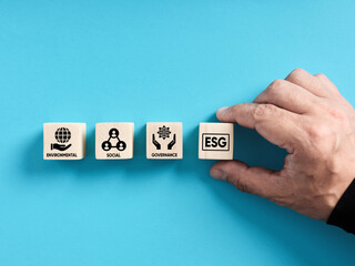 Environmental social governance. Sustainable corporation development concept. Male hand arranges the wooden blocks with the word ESG.