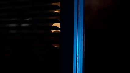 window with the background of the night. curtains fluttering in the wind. blurred night city background, red bokeh