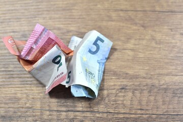 crumpled paper euro bills on a wooden table