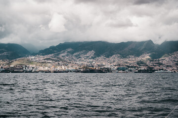 a body of water with mountains in the background, madeira