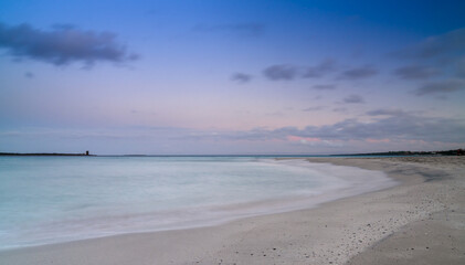coucher de soleil sur la pittoresque plage de sable blanc et les eaux turquoises de la plage de La Pelosa