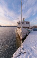Moored old steam ship at the pier Norr M&auml;larstrand a pale snowy winter day in Stockholm