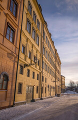 Old yellow court houses on the island Riddarholmen a pale snowy winter day in Stockholm