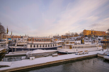 Naklejka premium View from the bridge Skeppsholmsbron moored commuting boat in background a pale snowy winter day in Stockholm