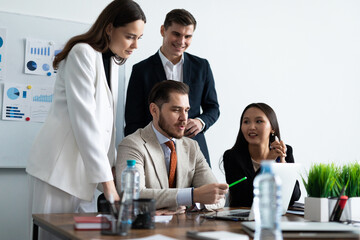 Smiling diverse colleagues gather in boardroom brainstorm discuss financial statistics together