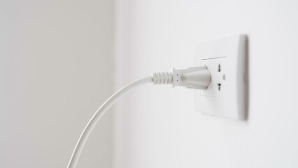Close up of hand plugging in power cord into socket to use energy, Reduce and saving energy efficiency