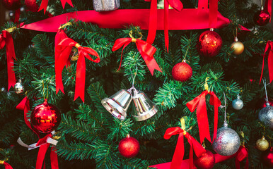 Twin silver bells and red ribbon with red Christmas balls adorn on Christmas tree.  Christmas background. New Year concept. - Powered by Adobe