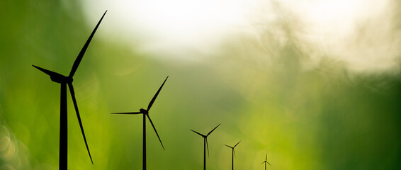 Silhouettes of wind turbines on green background © scharfsinn86