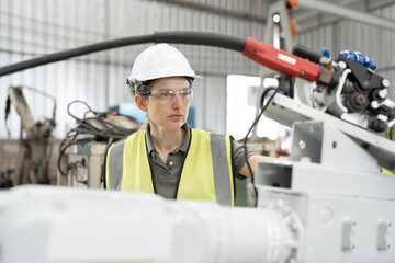 Caucasian technician engineer woman checking machine arm robot at factory