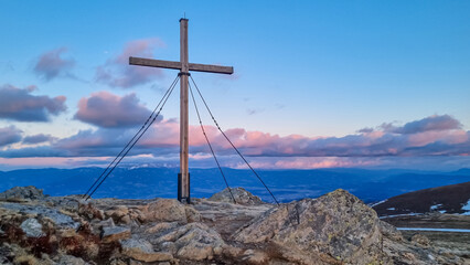 Scenic evening view during sunset on summit cross of mountain peak Zingerle Kreuz, Saualpe,...