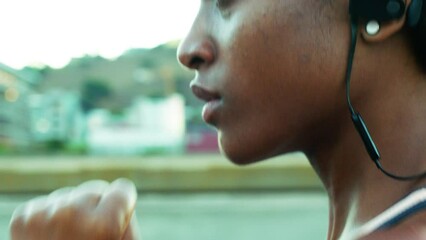 Fitness, woman and focus running in the city for workout, exercise or cardio training in the outdoors. Closeup of active female runner face in determination for sports run, exercising or endurance