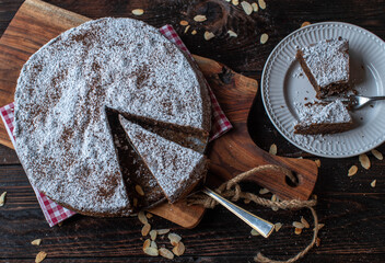 Italian chocolate cake with almonds. Torta caprese. Served on wooden and rustic cutting board. Top view. gluten free