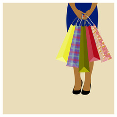 Swarthy woman holding speckled shopping bags on the beige background.