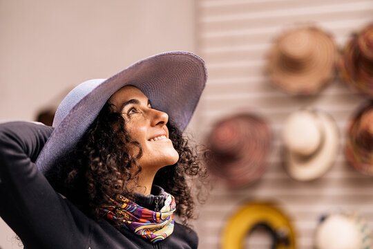 Happy woman in hat shop