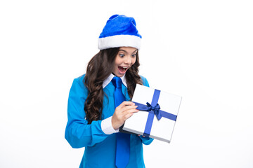 Child in winter wear holding gift for New Year or Christmas. Surprised emotions of young teenager girl.