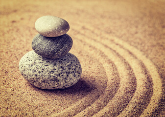 Fototapeta na wymiar Vintage retro effect filtered hipster style image of Japanese Zen stone garden - relaxation, meditation, simplicity and balance concept - pebbles and raked sand tranquil calm scene