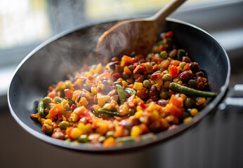 cooking tasty vegetable mix with corn, pea, beans in pan on kitchen