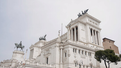 Obraz premium Low angle view of a beautiful building with sculptures of horses on its roof. Action. Concept of classic architecture.
