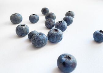 Large blueberries are scattered on a white table. Selective focus.