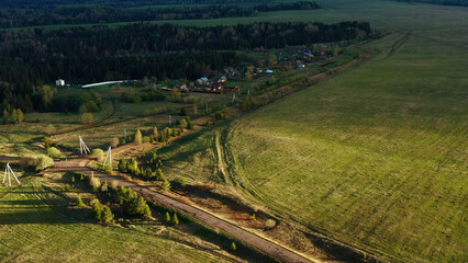 Rural landscape with a tiny village, green fields and trees. Clip. Agricultural landscape with countryside road and summer meadows.