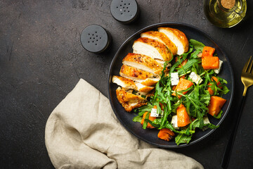 Chicken salad with pumpkin and arugula.