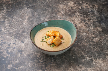 Fototapeta na wymiar mushroom soup puree with croutons on gray background