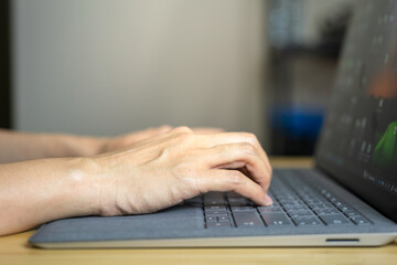Action of a businessperson is typing on the modern design laptop keyboard to input or program data, business working concept scene. Close-up and selective focus at human hand's part.