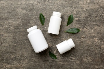 supplement pills with medicine bottle health care and medical top view. Vitamin tablets. Top view mockup bottle for pills and vitamins with green leaves, natural organic bio supplement, copy space