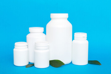 supplement pills with medicine bottle health care and medical top view. Vitamin tablets. Top view mockup bottle for pills and vitamins with green leaves, natural organic bio supplement, copy space