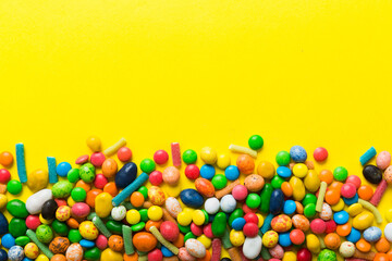 Mixed collection of colorful candy, on colored background. Flat lay, top view. frame of colorful chocolate coated candy