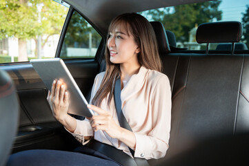 Fototapeta na wymiar Young asian beautiful businesswoman working with tablet in the car