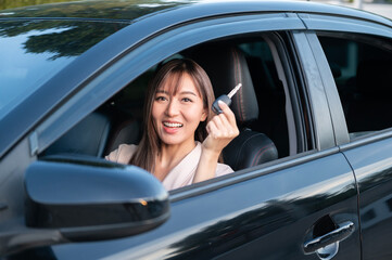 Young asian beautiful woman driving a car with fastened seatbelt