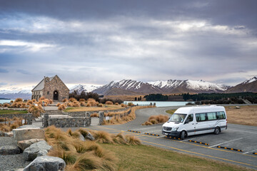 Sunrise view of the Lake Tekapo in late winter with snow capped mountain at the background, New Zealand South Island. Best way to travel the country via road trip with camper van.  - obrazy, fototapety, plakaty