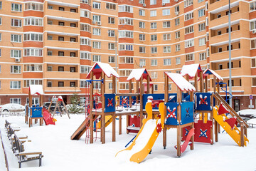 A new children's playground in the courtyard of a multi-storey residential building in winter. A new neighborhood. Moscow region. Prominent. Boulevard Green alleys.